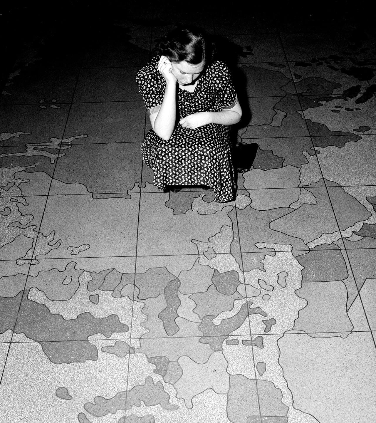 European situation spoils map on Post Office department floor. Washington, D.C., April 12. The huge map on the floor of the Post Office Department here is all out of kilter these days due to the aggression in Europe. Many are the embarrassing questions being asked officials about when Mr. Farley is going to do something about Ethiopia, Austria and Czechoslovakia. The answer so far has been - nothing. Probably the Post Office is waiting to see what will happen next on the continent. Miss Edna Strain is inspecting the damage done by the ambitious dictators. 4-12-39
